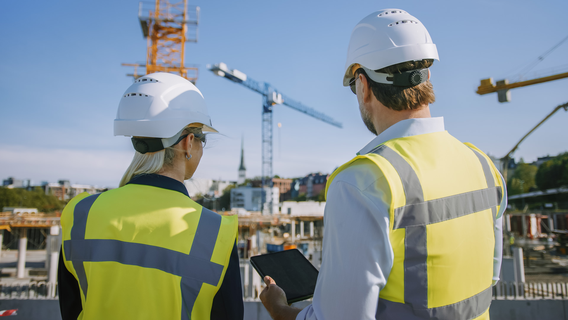 Architect and civil engineer use a tablet on a city construction site